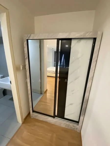 Room features: built-in wardrobe with mirrored doors, marble accents on wardrobe frame, wooden flooring, neutral wall color, doorway leading to another room, visible floor tiles in adjacent area; style: modern.