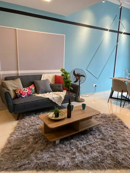 Living features: grey fabric sofa, colorful throw pillows, wooden coffee table, fluffy area rug, floor fan, decorative plant, wall-mounted artwork, light blue painted walls, recessed ceiling lights, dining table in background; style: modern.