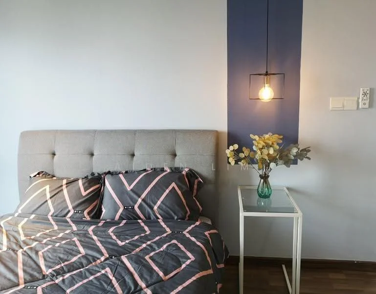 Bedroom features: queen-size bed with grey upholstered headboard, black and pink geometric patterned bedding, nightstand with glass top, decorative vase with flowers, pendant light fixture, blue accent wall, wooden flooring, wall-mounted electrical outlets; style: modern.