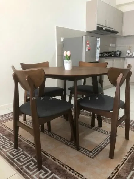 Dining features: round wooden dining table, 4 wooden dining chairs with upholstered seats, decorative vase with flowers on table, cream walls, tile flooring, kitchen area visible in background, stainless-steel fridge, built-in kitchen cabinets, stove and hood above kitchen counter; style: modern.