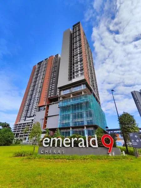 Exterior type: high-rise condominium; features: glass curtain wall, red brick facade, green mesh covering, manicured lawn, surrounded by greenery, prominent signage, multiple storeys, modern architectural design; style: modern.