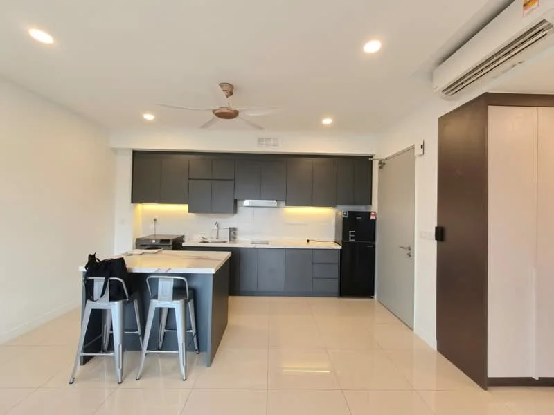 Kitchen features: white painted walls, glossy tile flooring, ceiling fan, recessed downlights, black cabinetry, white countertop, stainless-steel sink, chrome pull-down faucet, built-in oven, freestanding fridge, kitchen island with seating, bar stools, wall-mounted air conditioning unit; style: modern.