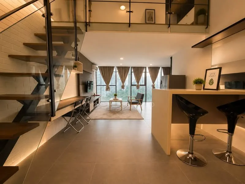 Living features: grey tiled flooring, white painted walls, exposed brick wall, large floor-to-ceiling windows, sheer curtains, 2-seater fabric sofa, coffee table, TV console, wall-mounted TV, area rug, decorative plant, wooden shelving unit, recessed downlights, ceiling fan; style: modern; view: city. Kitchen features: bar counter with 2 black stools, white cabinetry, kitchen island, stainless-steel sink, chrome pull-down faucet, recessed lighting; style: modern.
