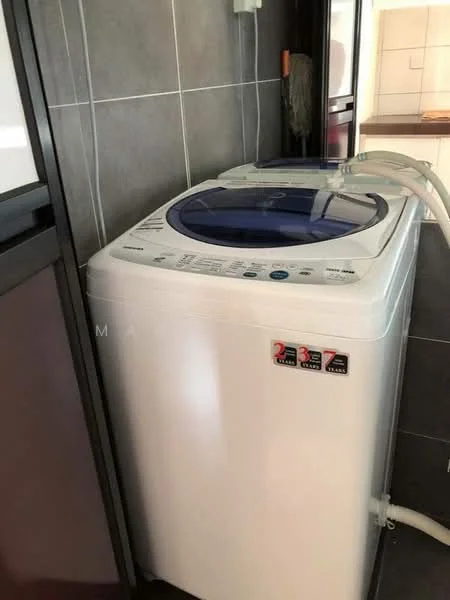 Laundry features: top-load washing machine, white exterior, control panel with buttons, drain hose, water inlet hose, grey tiled walls, dark flooring, built-in cabinetry; style: modern.