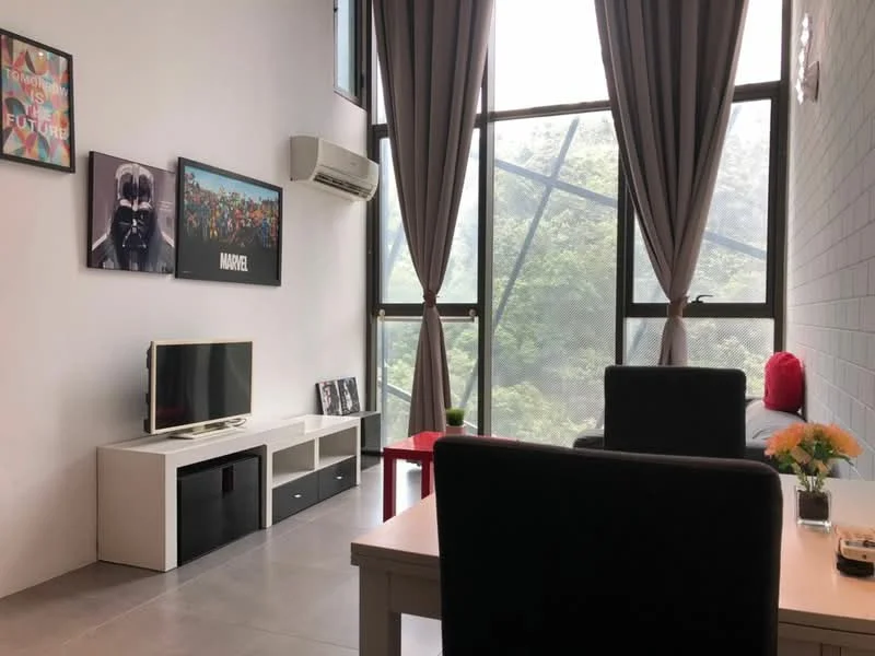 Living features: floor-to-ceiling windows, grey tiled flooring, white painted walls, wall-mounted TV, TV console with storage, black armchair, red accent chair, dining table with chairs, decorative flowers on table, air conditioning unit, framed artwork on walls, curtains, open layout; style: modern; view: greenery.