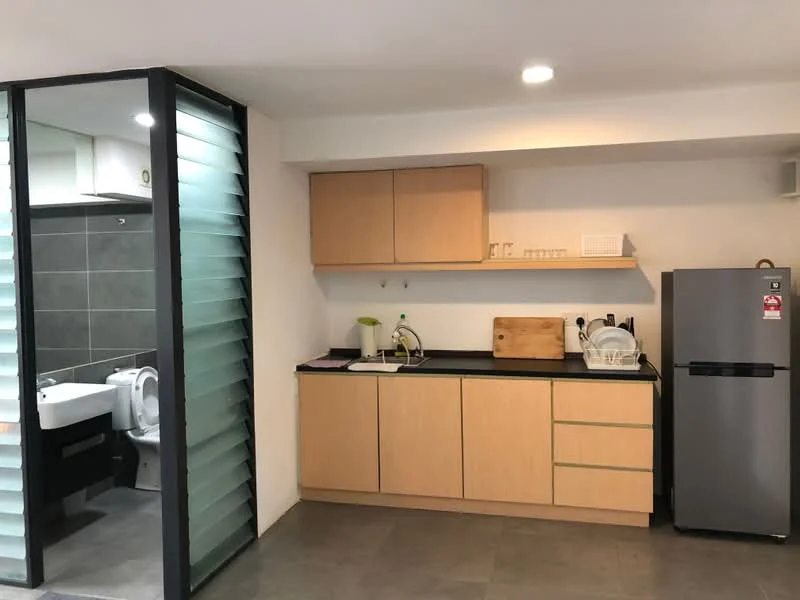 Kitchen features: light wood cabinetry, black countertop, single-bowl stainless-steel sink, chrome pull-down faucet, built-in microwave, stainless-steel fridge, ceramic tile flooring, recessed downlights; style: modern. Bathroom features: white toilet, grey tile walls, grey tile flooring, sink with vanity, mirror above sink.