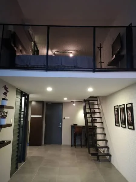 Living features: grey tiled flooring, white painted walls, staircase with metal railing, wall-mounted TV, recessed downlights, open shelving with decorative plants, dining table with chairs, door leading to hallway; style: modern. Bedroom features: bed with headboard, wall-mounted light fixtures, open space above living area; style: modern.
