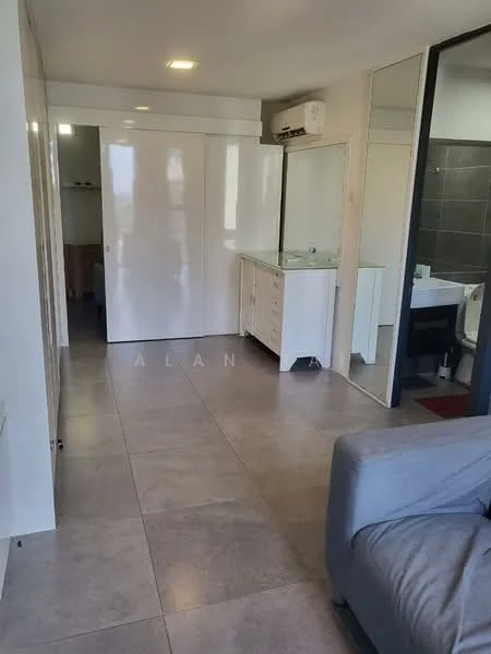 Room features: light grey tiled flooring, white painted walls, built-in wardrobe with sliding doors, wall-mounted air conditioning unit, vanity with sink, mirror above vanity, dark tiled wall in bathroom area, open layout, natural light from windows, sofa in living area; style: modern.