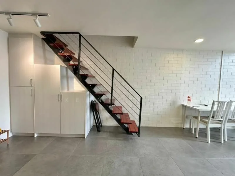 Room features: white painted walls, exposed brick wall, grey tile flooring, wooden staircase with metal railing, built-in cabinetry, dining table with chairs, floor lamp, umbrella stand; style: modern.