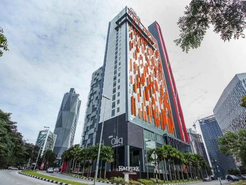 Exterior type: high-rise condominium; features: glass curtain wall, orange and white facade, projecting balconies, approximately 20-storey high-rise, manicured landscaping, surrounded by urban context; style: modern.