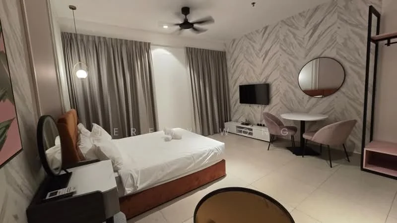Bedroom features: queen-size bed with white bedding, upholstered headboard in brown, 2 white towels on bed, round mirror on wall, wall-mounted TV, dining table for 2 with black chairs, ceiling fan, grey curtains, light-colored tiled flooring, decorative wall with herringbone pattern, side table with lamp, built-in wardrobe; style: modern.