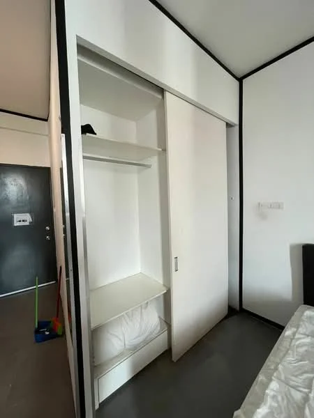 Room features: white painted walls, sliding wardrobe door, built-in shelving, open storage space, grey flooring; style: modern.