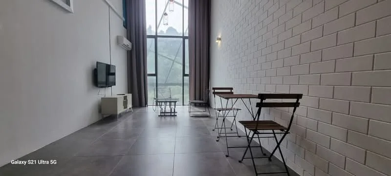Living features: white painted walls, grey tiled flooring, floor-to-ceiling windows, wall-mounted TV, 1 wall-mounted split AC, 2 small wooden folding chairs, small rectangular table, decorative rug, hanging pendant lights, curtains, exposed brick wall, open layout; style: modern; view: mountain.