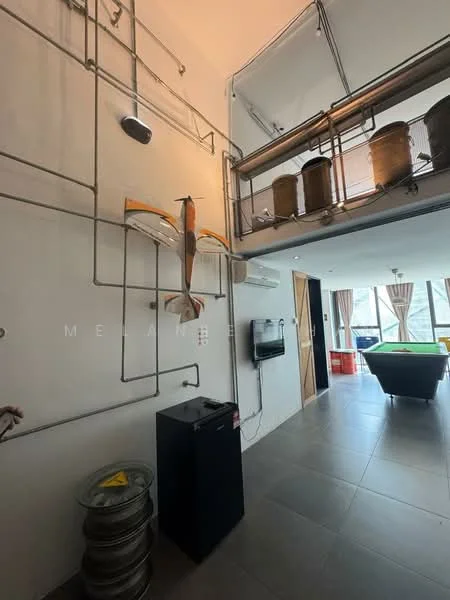Room features: grey tiled flooring, white painted walls, exposed metal piping, decorative wall art, wall-mounted TV, refrigerator, large windows with natural light, curtains, pool table, wooden door, ceiling with visible structure; style: modern; view: city.