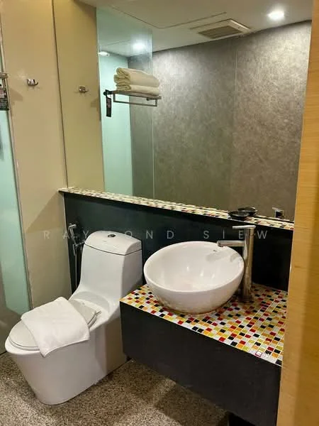 Bathroom features: one-piece toilet, round vessel sink, chrome faucet, colorful mosaic tile backsplash, grey wall tiles, mirror, glass shower enclosure, towel rack, stone flooring; style: modern.