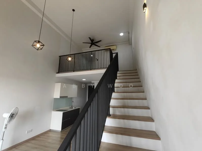 Room features: high ceiling, wooden staircase, black metal railing, ceiling fan with light, pendant lighting, white painted walls, laminate flooring, open kitchen area, kitchen cabinetry, kitchen countertop, wall-mounted air conditioning unit, large windows for natural light; style: modern.