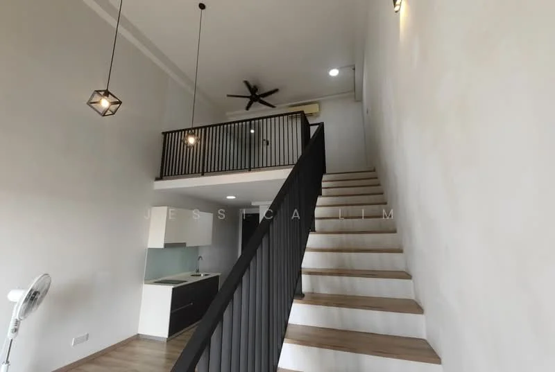 Room features: staircase with wooden steps, black metal railing, ceiling fan, pendant lighting fixtures, white painted walls, laminate flooring, open space with high ceiling, kitchen area visible in background; style: modern.