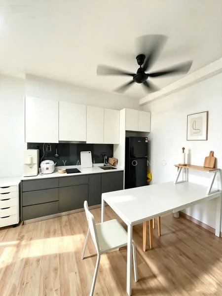 Kitchen features: white upper cabinets, grey lower cabinets, black countertop, stainless-steel sink, chrome pull-down faucet, built-in stove, refrigerator, ceiling fan, wooden flooring, dining table, white chairs, kitchen appliances, wall-mounted artwork; style: modern.