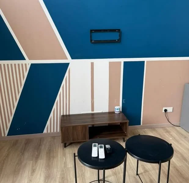 Room features: geometric accent wall with blue, pink, and white colors, light wood flooring, wooden TV console, two black side tables, wall-mounted TV bracket, electrical outlet on wall; style: modern.