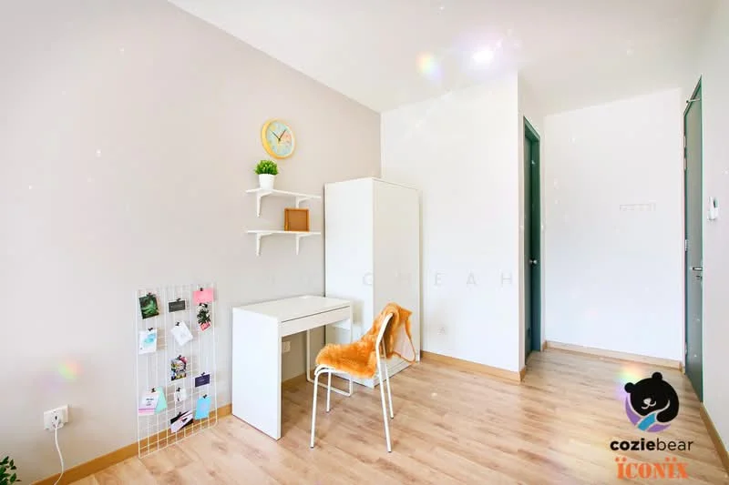 Room features: light wood laminate flooring, white painted walls, wall-mounted shelf, white desk, white chair, decorative wall clock, framed artwork on wall, green door, natural light from window; style: modern.