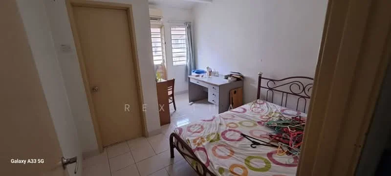 Bedroom features: queen-size bed, metal bed frame with headboard, white painted walls, tiled flooring, window with sheer curtains, study desk, chair, built-in wardrobe, light fixture on ceiling, decorative bedspread with circular pattern.