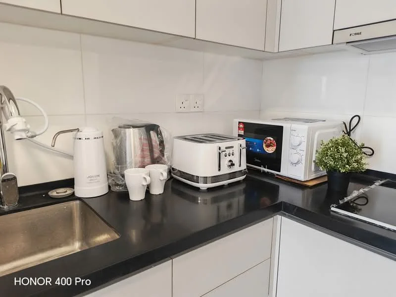 Kitchen features: single-bowl stainless-steel sink, chrome pull-down faucet, black countertop, white cabinetry, built-in microwave, toaster, electric kettle, 2 white cups, small potted plant, stainless-steel range, ceramic tile backsplash; style: modern.