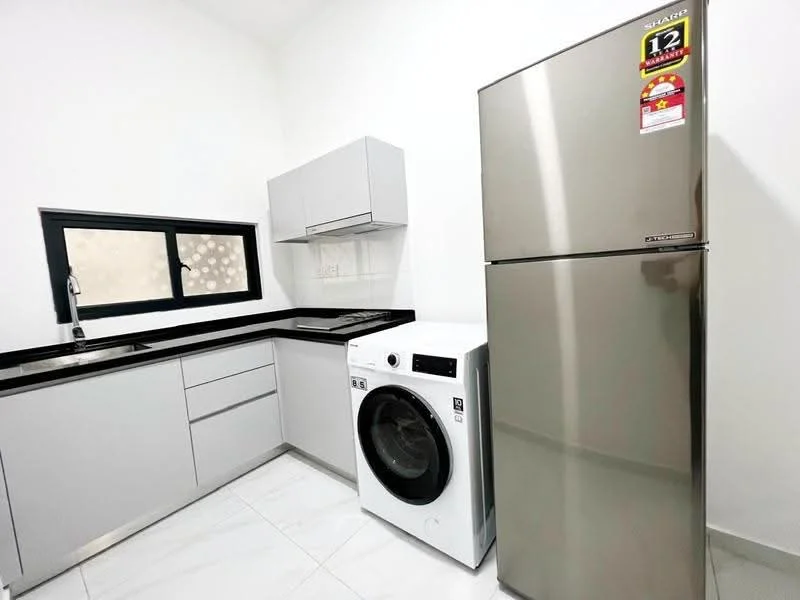Kitchen features: grey cabinetry, black countertop, stainless-steel sink, chrome pull-down faucet, built-in washing machine, stainless-steel fridge, white walls, tile flooring; style: modern.