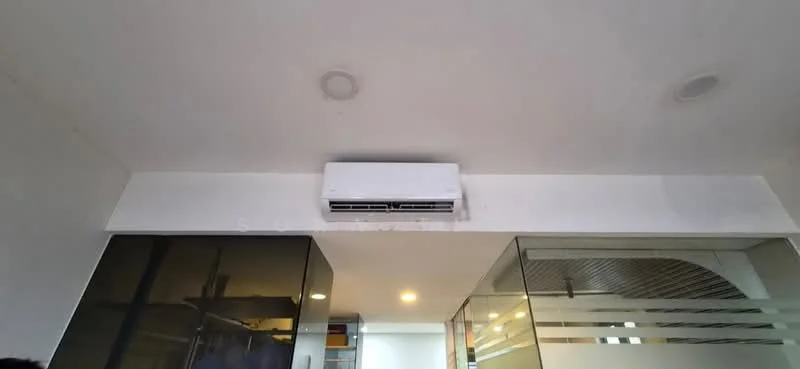 Room features: wall-mounted split AC, recessed downlights, white painted walls, glass partition, open shelving.