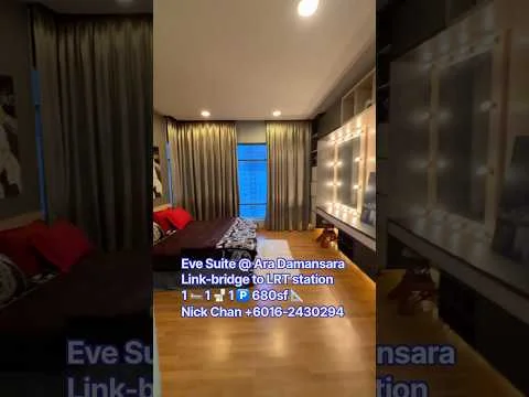 Living features: grey fabric sofa, red accent pillows, large floor-to-ceiling windows, sheer curtains, dark wood flooring, decorative wall with lighting, wall-mounted TV, area rug with geometric pattern, coffee table, framed artwork, built-in shelving, decorative plants; style: modern; view: city.