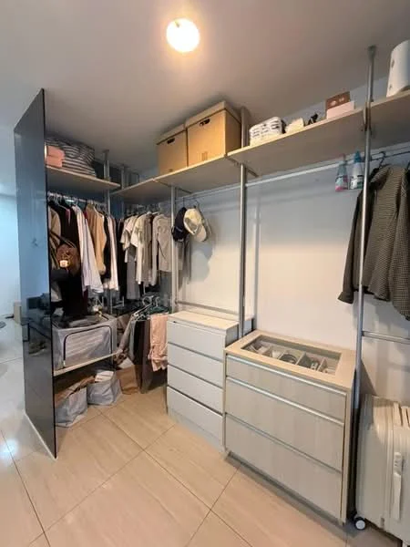 Room features: built-in shelving, hanging rods for clothes, drawers, storage boxes, light fixture, neutral wall color, tile flooring, clothes organized by type; style: modern.