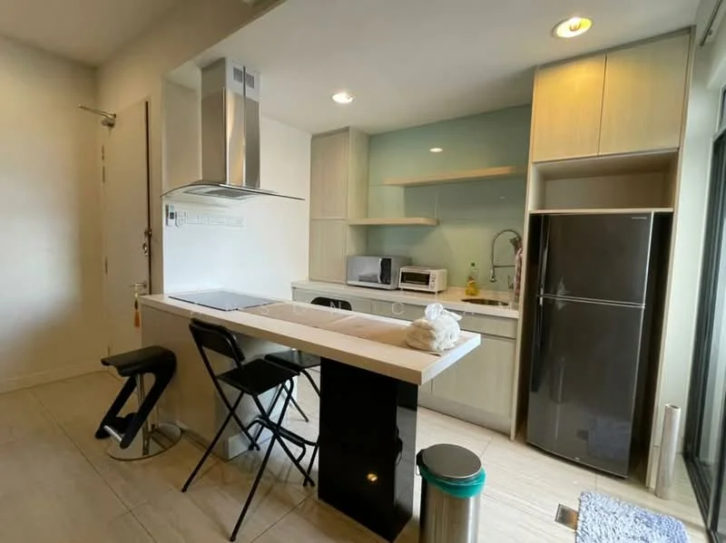 Kitchen features: white cabinetry, light wood upper cabinets, black lower cabinets, white countertop, stainless-steel range hood, built-in microwave, stainless-steel fridge, single-bowl stainless-steel sink, chrome pull-down faucet, ceramic tile flooring, recessed downlights, open shelving, bar seating area, two black folding chairs; style: modern.