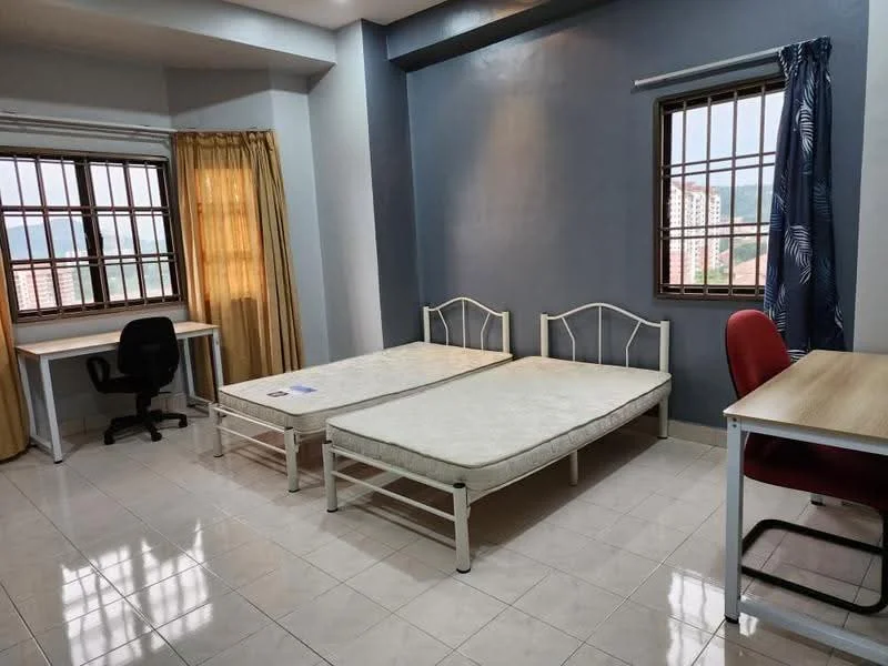 Bedroom features: two single beds with metal frames, white walls, grey accent wall, large window with metal grille, curtains in yellow and blue, study desk with wooden top, black office chair, white tiled flooring, built-in wardrobe, natural light from window; style: modern; view: city.