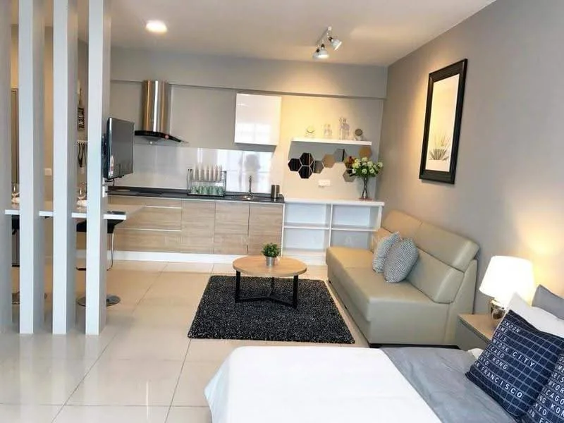 Living features: light grey painted walls, white ceiling, recessed downlights, 3-seater beige leather sofa, coffee table, area rug with geometric pattern, wall-mounted TV, decorative wall shelf, framed artwork, floor-to-ceiling windows, potted plants, side table with lamp; style: modern. Kitchen features: light wood cabinetry, white countertop, stainless-steel sink, chrome pull-down faucet, built-in oven, stainless-steel range hood, 4-burner gas hob, ceramic tile backsplash, bar stools, open shelving; style: modern.