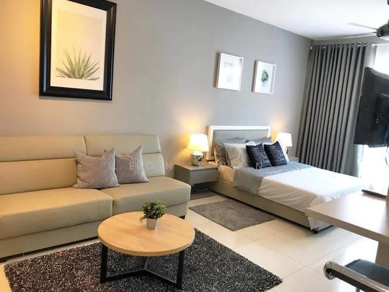 Living features: light grey painted walls, white ceiling, 3-seater fabric sofa in beige, 2 decorative cushions on sofa, round coffee table with wooden top, area rug with geometric pattern, floor lamp, wall-mounted TV, bed with grey bedding, 2 bedside lamps, curtains in grey, framed artwork on walls, potted plant on coffee table; style: modern.