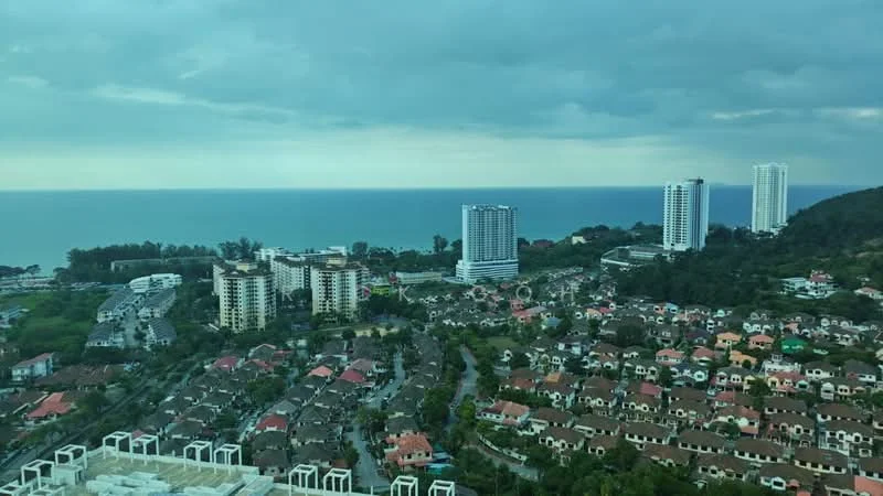 Exterior type: high-rise condominium; features: ocean view, city skyline, surrounded by greenery, multi-storey buildings, residential houses, coastal landscape; style: modern.