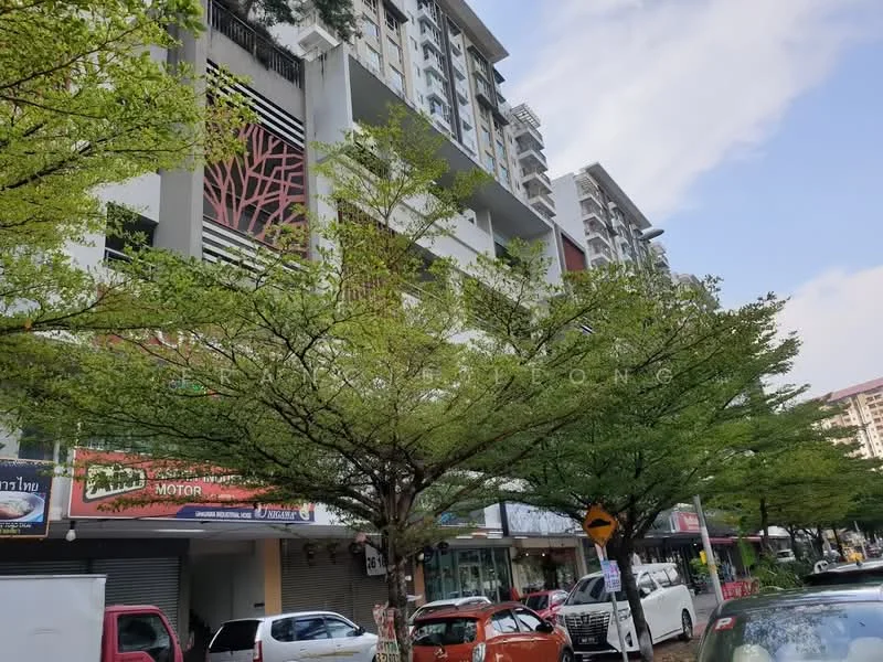 Exterior type: mid-rise condominium; features: white painted facade, glass curtain wall, recessed balconies, manicured landscaping with trees, street-level retail units, signage visible on storefronts, parking spaces visible, surrounded by mature greenery; style: modern.