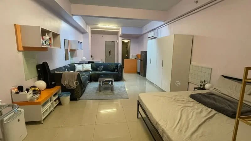 Living features: light purple painted walls, glossy tile flooring, sofa in dark fabric, coffee table, area rug, wall-mounted air conditioning unit, built-in wardrobe, open shelving unit, small refrigerator, decorative wall art, floor lamp, bed with grey bedding, dining table, kitchenette in background; style: modern.