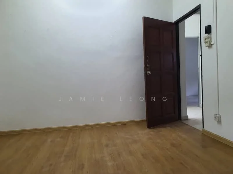 Room features: wooden flooring, white painted walls, brown wooden door, door frame, light switch, power outlet.