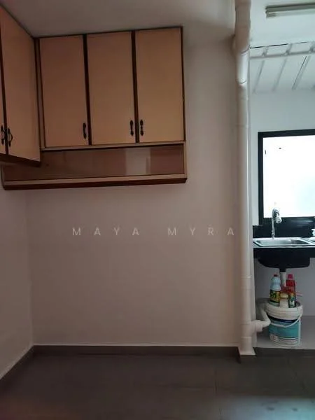 Laundry features: light grey tiled flooring, white painted walls, wooden cabinetry with beige finish, sink with chrome faucet, black countertop, visible plumbing, cleaning supplies storage, window for natural light.