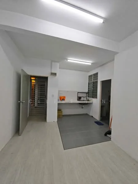 Room features: white painted walls, grey tile flooring, fluorescent ceiling lights, open layout, kitchen area with countertop, window with metal grilles, door leading to another room, clean and minimalistic design; style: modern.