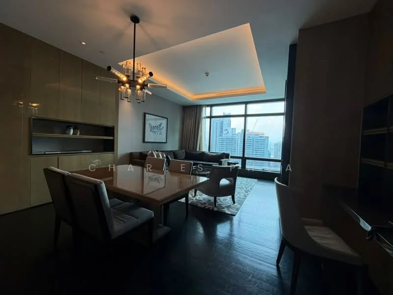 Living features: dark wood flooring, floor-to-ceiling windows, city view, chandelier with multiple bulbs, recessed lighting, light wood paneling, built-in shelving unit, area rug with geometric pattern, upholstered armchairs, glass-top dining table, upholstered dining chairs; style: modern.