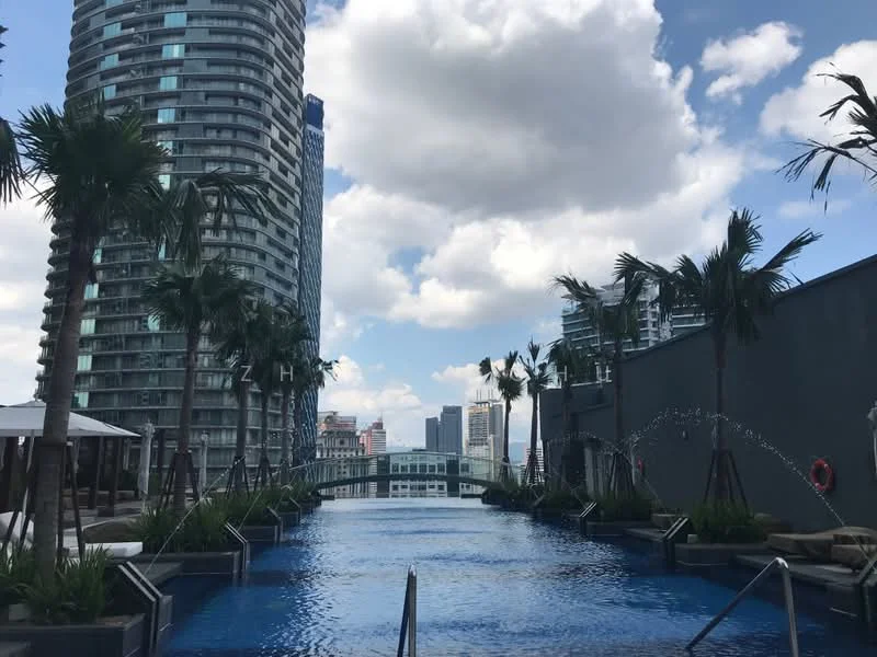 Exterior type: high-rise condominium; features: infinity pool, pool deck with loungers, tropical landscaping with palm trees, water features, surrounding high-rise buildings, city skyline in background; style: modern.