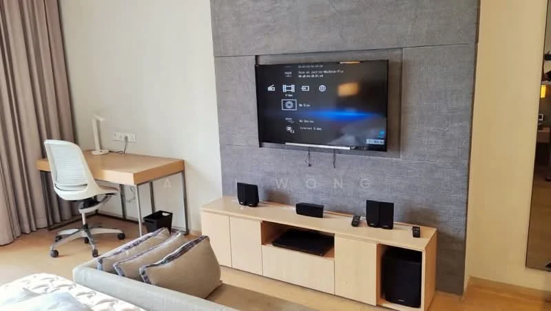 Living features: wall-mounted TV, light wood TV console, black speaker system, white desk chair, wooden desk, grey accent wall, curtains, sofa with cushions, wooden flooring; style: modern.