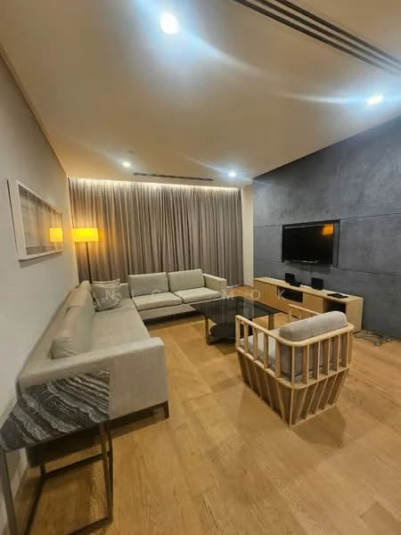 Living features: L-shape sectional sofa in light grey fabric, wooden coffee table, TV console with wall-mounted TV, wooden accent chair with open slats, floor-to-ceiling curtains in light grey, recessed downlights, wooden flooring, decorative wall with textured grey finish, side table with marble top; style: modern.
