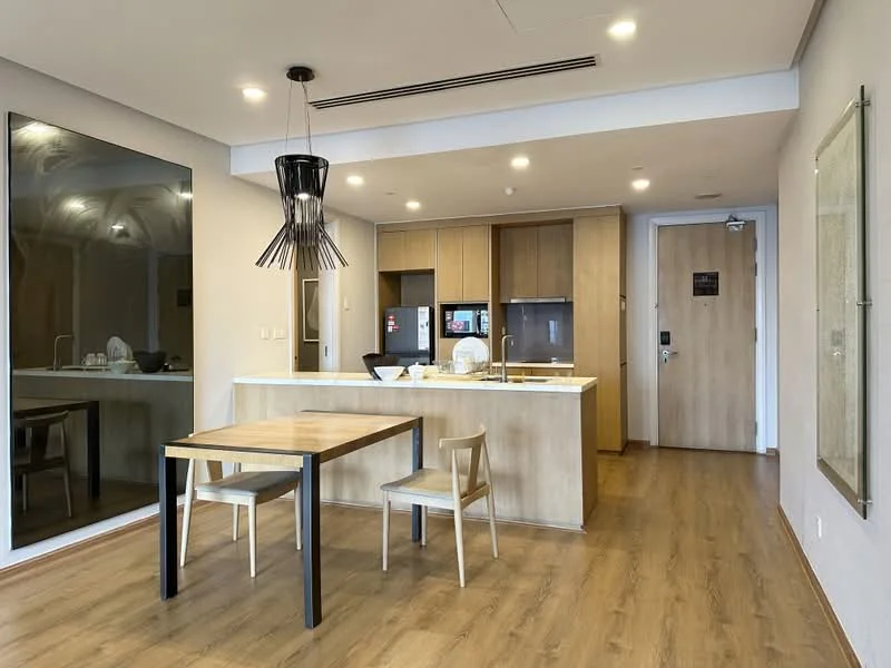Dining features: wooden dining table, 2 dining chairs, pendant light fixture, laminate flooring, open kitchen layout, kitchen island with countertop, stainless-steel fridge, built-in cabinets, wall-mounted TV, mirror wall, door to hallway; style: modern. Kitchen features: kitchen island, stainless-steel sink, chrome faucet, built-in oven, stainless-steel range hood, ceramic cooktop, wooden cabinetry, white countertop; style: modern.