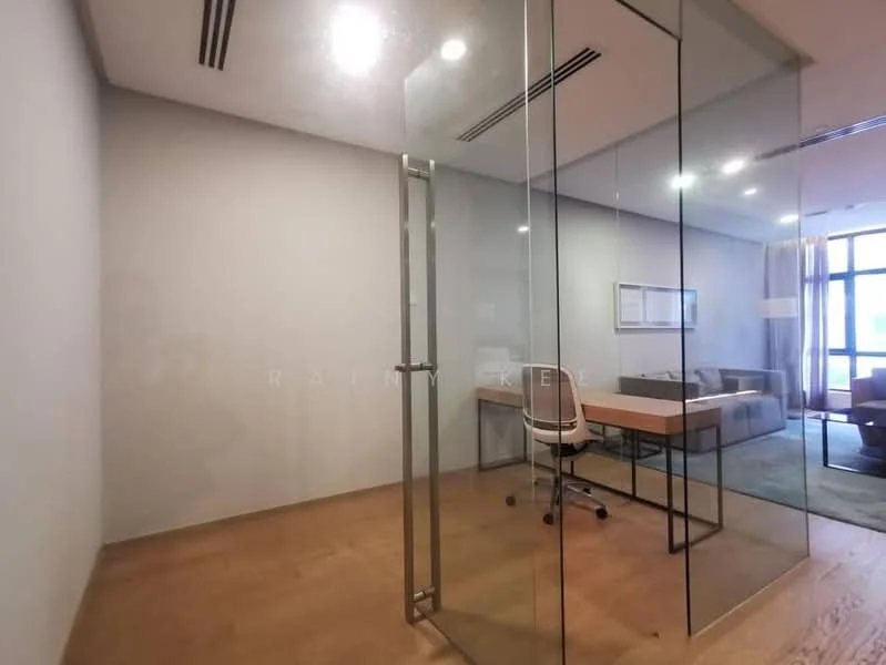Room features: glass partition, wooden flooring, recessed ceiling lights, desk with chair, sofa in background, curtains, window with view, neutral wall color; style: modern.