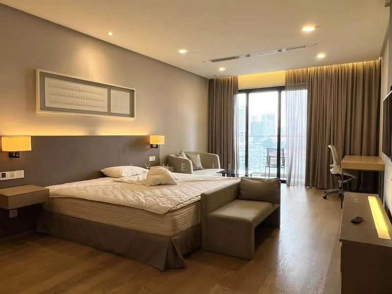 Bedroom features: king-size bed with upholstered headboard, bedside lamps, wall-mounted TV, study desk with chair, floor-to-ceiling windows, curtains, wooden flooring, recessed lighting, decorative wall art, sofa, neutral color scheme, built-in wardrobe; style: modern; view: city.
