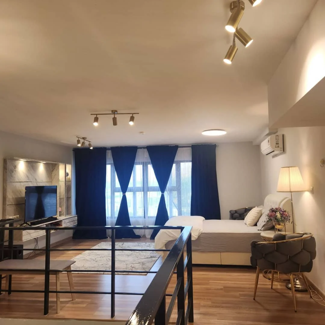 Living features: laminate flooring, white painted walls, recessed downlights, track lighting, floor-to-ceiling windows, blue curtains, sofa with decorative cushions, coffee table, TV console, wall-mounted TV, decorative vase with flowers, area rug with geometric pattern, air conditioning unit; style: modern; view: city.