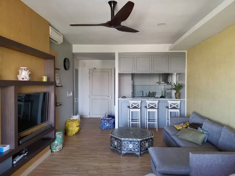 Living features: grey fabric sofa, coffee table with intricate design, wall-mounted TV, wooden TV console, 5-blade ceiling fan, laminate flooring, decorative wall with yellow paint, open kitchen with breakfast bar, bar stools, air conditioning unit; style: modern. Kitchen features: kitchen cabinets in light grey, stainless-steel sink, built-in stove, countertop with backsplash, open layout to living area; style: modern.