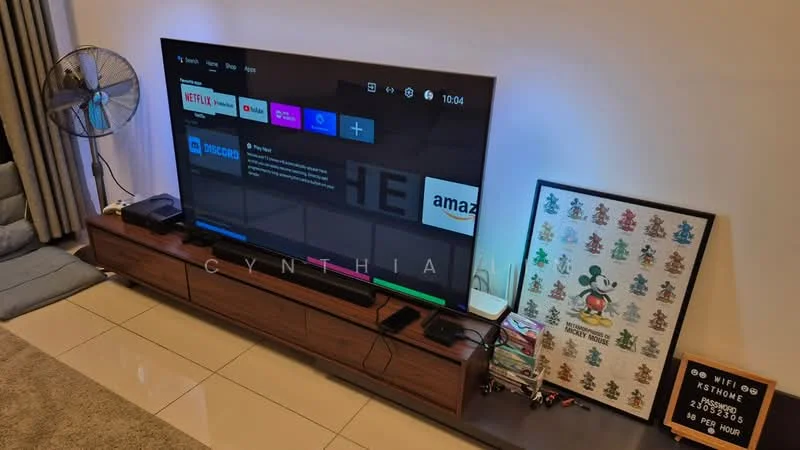 Living features: large flat-screen TV, wooden TV console, decorative framed artwork, area rug, wall-mounted fan, cream painted walls, tile flooring, cushioned seating, shelves with decorative items; style: modern.
